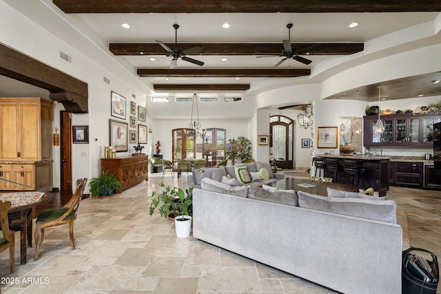 6102 E Sage Dr, Paradise Valley, AZ 85253 - living area featuring a ceiling fan, stone tile flooring, arched walkways, beamed ceiling, and a chandelier