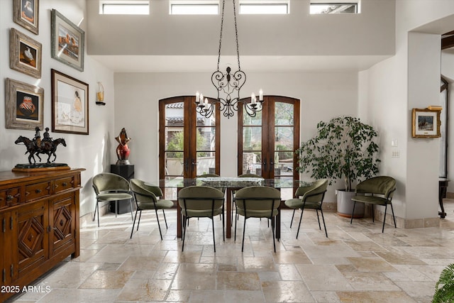 6102 E Sage Dr, Paradise Valley, AZ 85253 - dining room featuring stone tile flooring, french doors, a high ceiling, arched walkways, and a chandelier