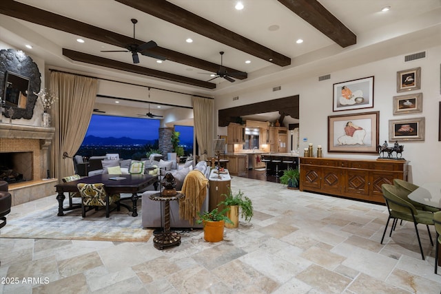 6102 E Sage Dr, Paradise Valley, AZ 85253 - living area featuring ceiling fan, beam ceiling, stone tile flooring, a fireplace, and recessed lighting