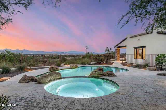 6102 E Sage Dr, Paradise Valley, AZ 85253 - pool at dusk with a mountain view, a fenced backyard, a patio area, and a pool with connected hot tub