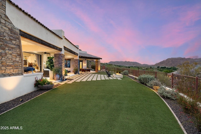 6102 E Sage Dr, Paradise Valley, AZ 85253 - yard at dusk with a patio, a ceiling fan, and a mountain view
