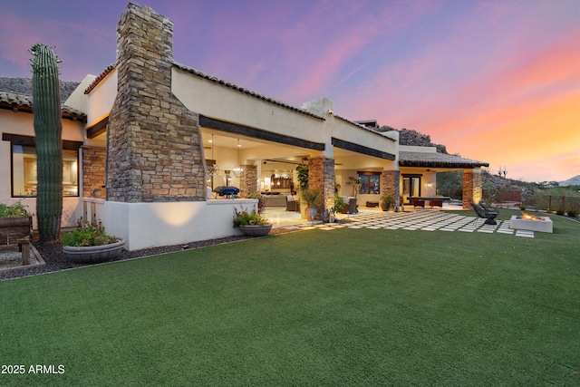 6102 E Sage Dr, Paradise Valley, AZ 85253 - back of house featuring stucco siding, a patio, and an outdoor living space with a fire pit