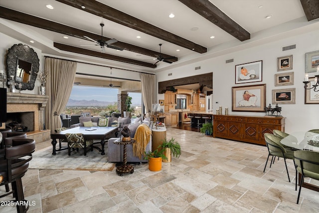 6102 E Sage Dr, Paradise Valley, AZ 85253 - dining room with a ceiling fan, beam ceiling, a mountain view, stone tile floors, and a fireplace
