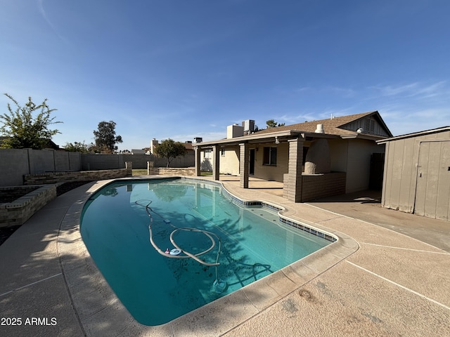 view of swimming pool with a fenced in pool, a storage unit, a patio area, a fenced backyard, and an outdoor structure