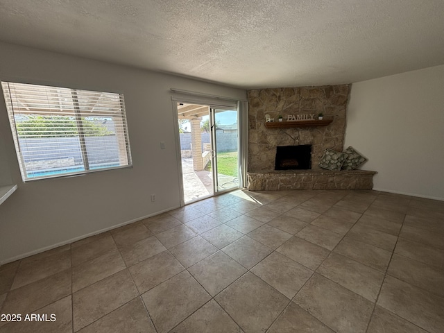 unfurnished living room featuring a fireplace, tile patterned flooring, and a textured ceiling