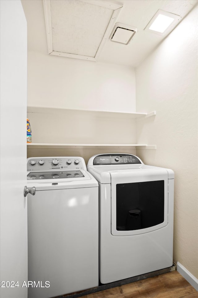 laundry area featuring washing machine and clothes dryer and dark wood-type flooring