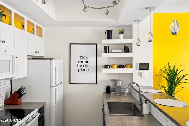 kitchen featuring white cabinets, white appliances, hanging light fixtures, and sink