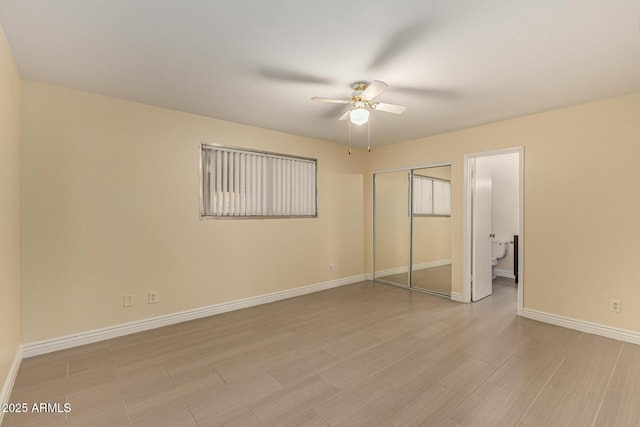 unfurnished bedroom with a closet, ceiling fan, light wood-style flooring, and baseboards