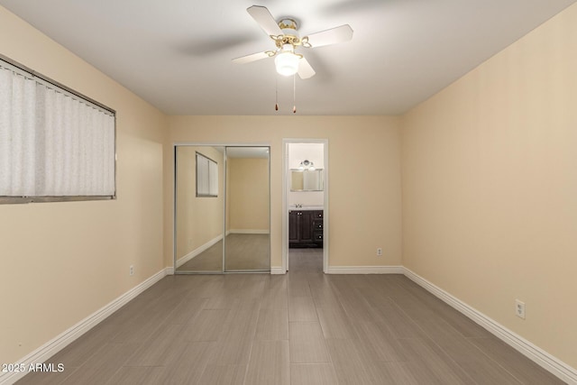 unfurnished bedroom with a ceiling fan, baseboards, a closet, and wood finished floors