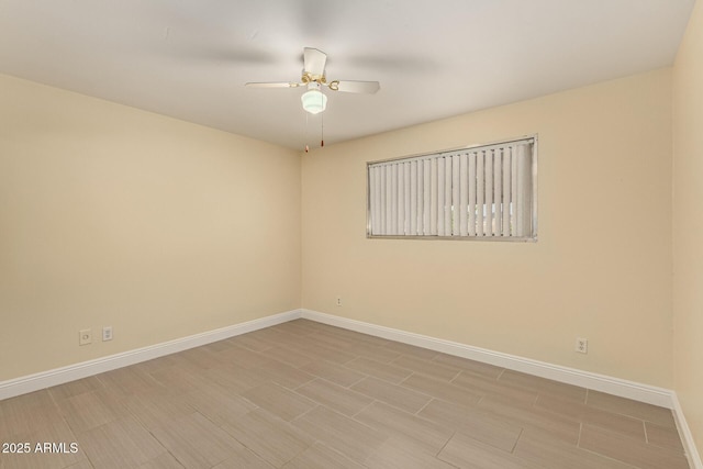 unfurnished room featuring ceiling fan and baseboards