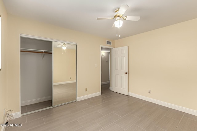 unfurnished bedroom featuring a ceiling fan, visible vents, baseboards, and a closet