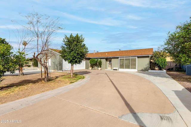 single story home featuring driveway, an attached garage, and fence