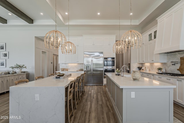 kitchen with stainless steel appliances, dark wood-style floors, a large island, and a chandelier