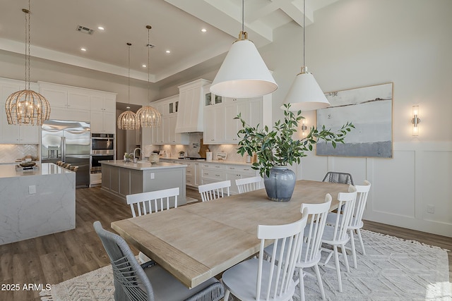 dining area with visible vents, dark wood-style floors, an inviting chandelier, a decorative wall, and recessed lighting