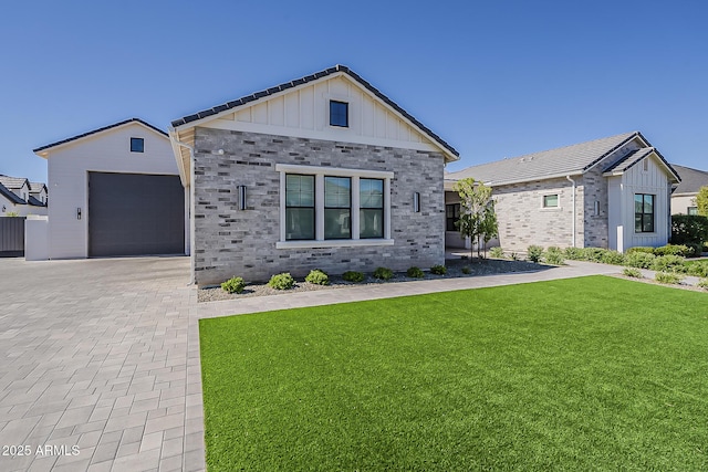 view of front of property featuring board and batten siding, decorative driveway, stone siding, and a front lawn