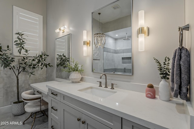 full bathroom featuring vanity, a shower stall, and visible vents