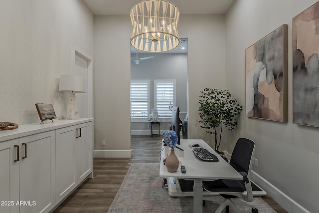 home office with baseboards, a notable chandelier, and dark wood-style floors