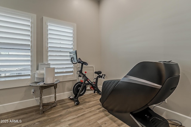 workout room with baseboards and wood finished floors