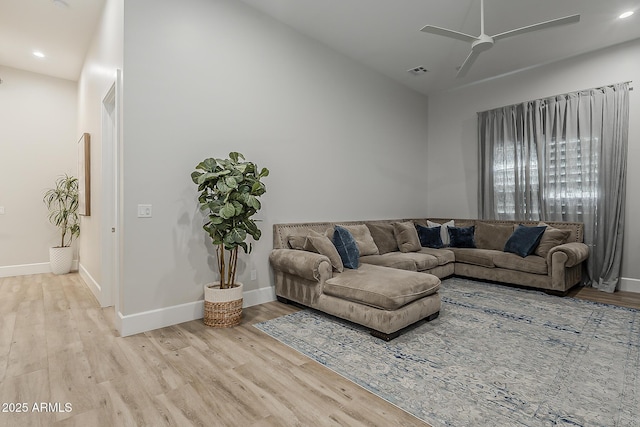 living room featuring visible vents, light wood-style flooring, and ceiling fan
