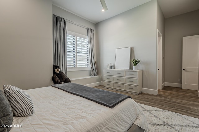 bedroom with baseboards, ceiling fan, and wood finished floors