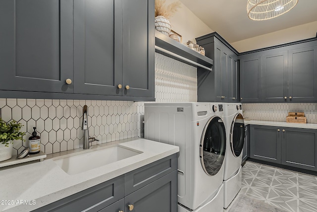 laundry room with a sink, cabinet space, and washer and clothes dryer