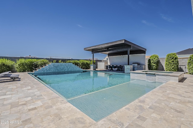 view of swimming pool with grilling area, a patio, a pool with connected hot tub, and exterior kitchen