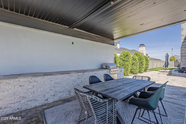 view of patio featuring grilling area, fence, outdoor dining area, and area for grilling