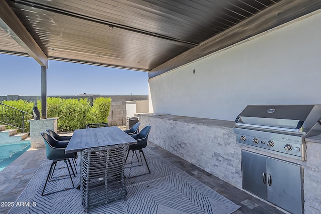 view of patio / terrace featuring outdoor dining area, an outdoor kitchen, and a grill