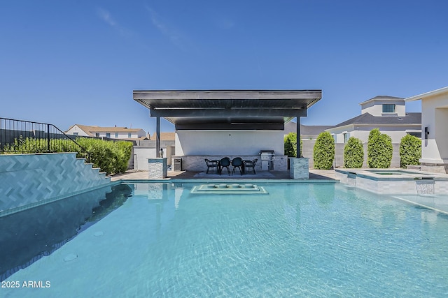 view of swimming pool featuring fence, area for grilling, a patio area, a pool with connected hot tub, and stairway
