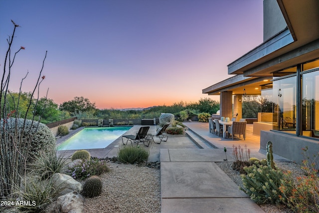 pool at dusk with a patio