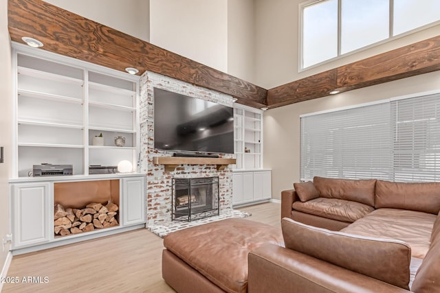 3514 E Desert Willow Rd, Phoenix, AZ 85044 - living room featuring light wood finished floors, built in shelves, a fireplace, baseboards, and a high ceiling
