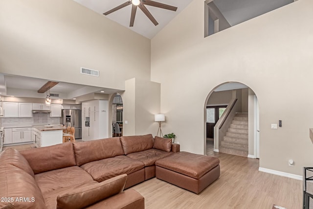 3514 E Desert Willow Rd, Phoenix, AZ 85044 - living room featuring ceiling fan, arched walkways, baseboards, light wood finished floors, and high vaulted ceiling