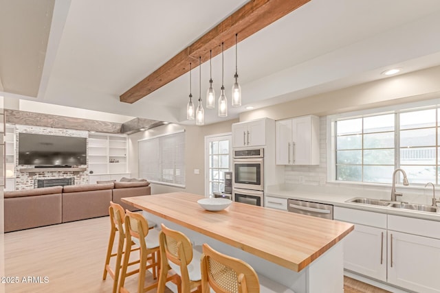 3514 E Desert Willow Rd, Phoenix, AZ 85044 - kitchen with a sink, appliances with stainless steel finishes, a breakfast bar area, beam ceiling, and decorative light fixtures