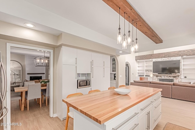 3514 E Desert Willow Rd, Phoenix, AZ 85044 - kitchen with a fireplace, stainless steel microwave, butcher block countertops, arched walkways, and beam ceiling