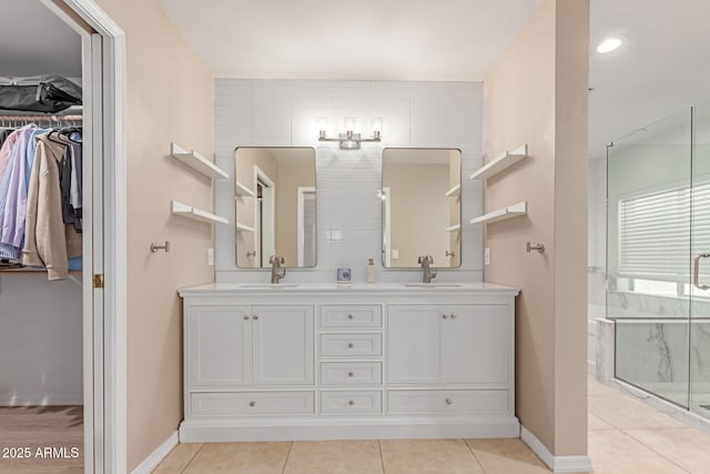 3514 E Desert Willow Rd, Phoenix, AZ 85044 - full bathroom featuring double vanity, a stall shower, baseboards, a walk in closet, and tile patterned flooring