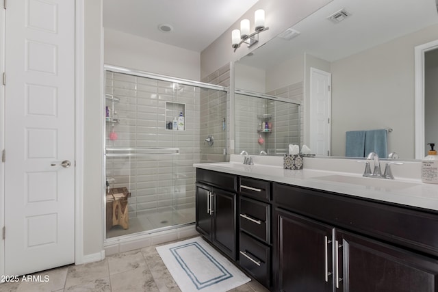 bathroom featuring vanity and a shower with shower door