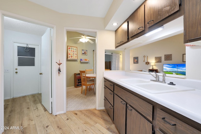 kitchen featuring ceiling fan, sink, and light hardwood / wood-style flooring