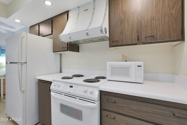 kitchen with dark brown cabinets, white appliances, and extractor fan