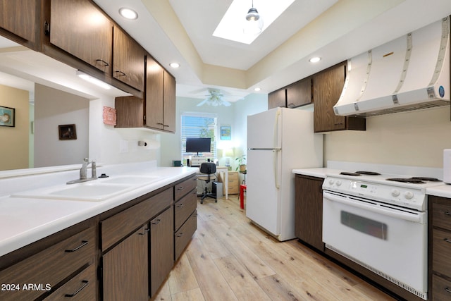 kitchen with light wood-type flooring, a skylight, white appliances, sink, and exhaust hood