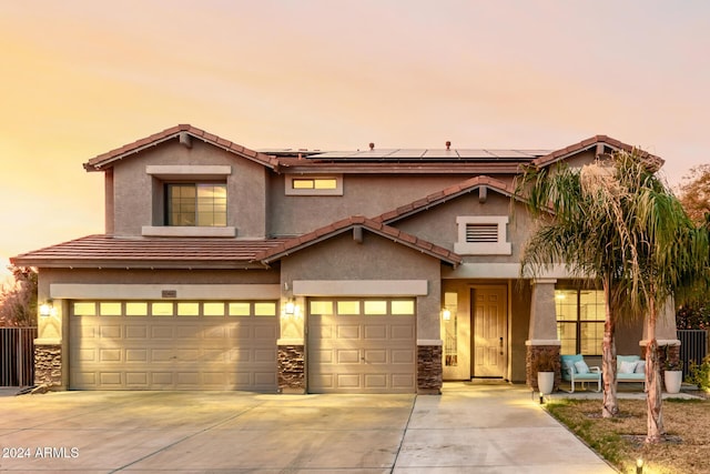 view of front of home featuring solar panels and a garage