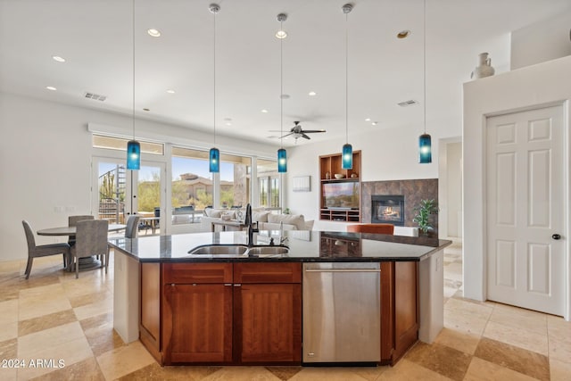 kitchen with ceiling fan, a center island with sink, hanging light fixtures, and sink