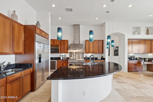 kitchen with sink, a center island with sink, decorative light fixtures, and high end appliances