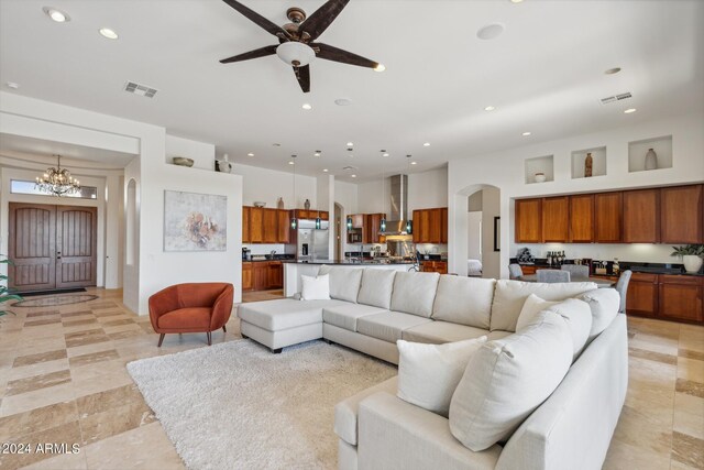 living room featuring ceiling fan with notable chandelier