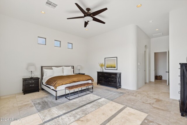 bedroom featuring ceiling fan and a towering ceiling