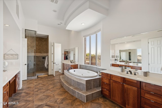 full bathroom with toilet, a high ceiling, vanity, and separate shower and tub