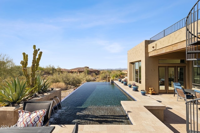 view of pool featuring pool water feature and a patio area