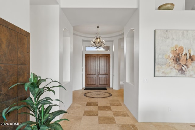 entrance foyer with a raised ceiling and an inviting chandelier