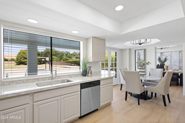 kitchen featuring a wealth of natural light, white cabinets, stainless steel dishwasher, and light wood-type flooring