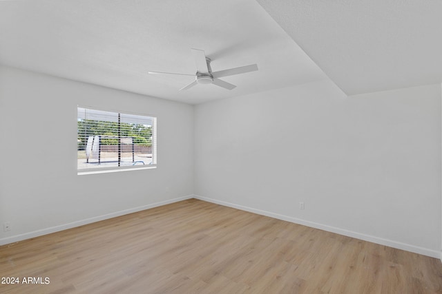 empty room with ceiling fan and light hardwood / wood-style floors