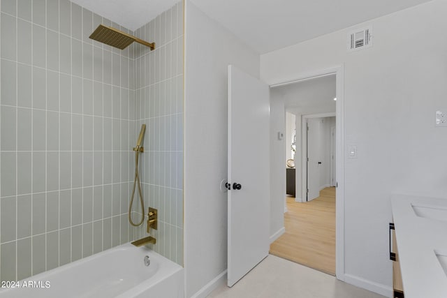 bathroom featuring vanity and tiled shower / bath combo